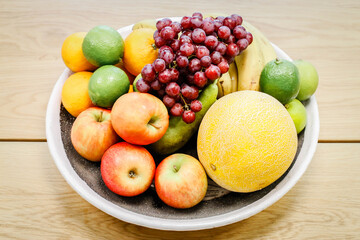 A bowl of fruit sits on a table in an apartment.