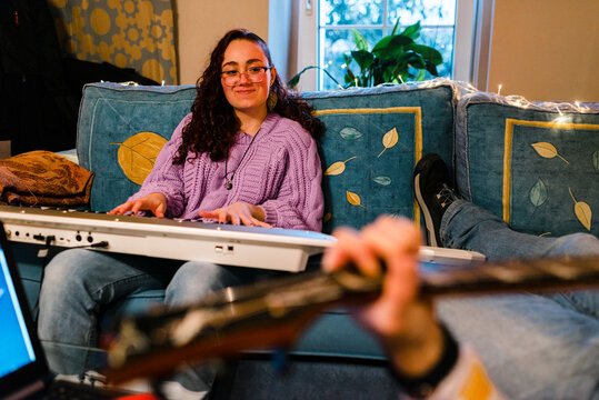 Sweet couple of young musicians playing at home