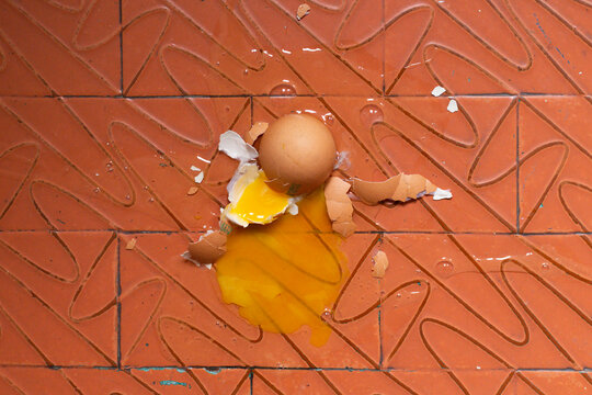 broken egg on red dirty rustic floor