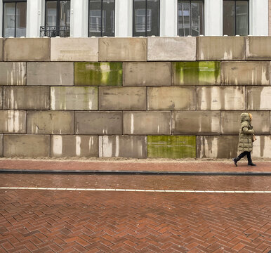 pedestrian walking in front of wall