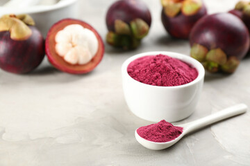 Purple mangosteen powder and fruits on light grey table