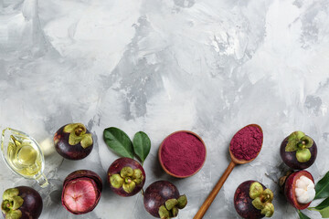 Purple mangosteen powder and fruits on light grey table, flat lay. Space for text