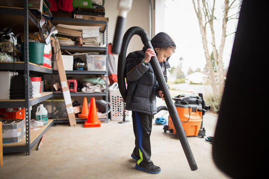 Boy with shop vac in garage
