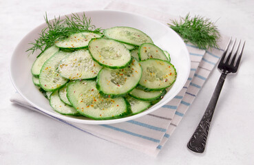 Fresh cucumber salad in bowl on white background