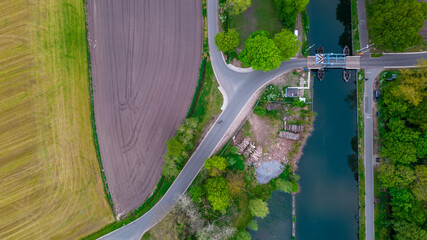 aerial shot of a drawbridge over a canal or river in a green countryside landscape in Flanders, Belgium. High quality photo