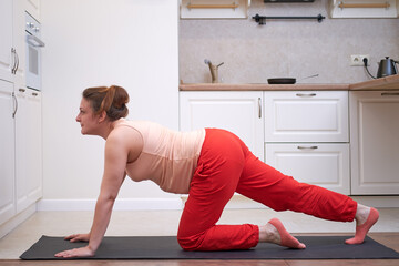 Fitness at home during pregnancy with body training on the floor. Pregnant woman at a sports...