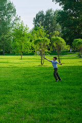 A boy plays badminton during outdoor recreation, lawn in the park