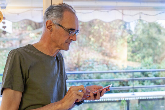 banking online, senior elderly man using smartphone at home, mobile internet on the phone