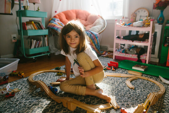 girl playing with trains in her bedroom