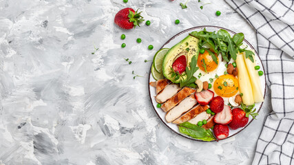 keto ketogenic diet Fried egg, avocado, strawberry, grilled chicken fillet, cheese, nuts and arugula, Ketogenic diet. Low carb high fat breakfast, top view