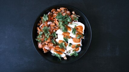 Salt egg spicy salad with dried shrimps on black background, Thai food breakfast.