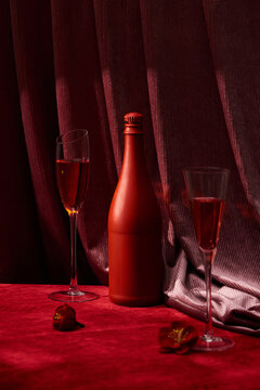 bottle and glass with red wine on color background