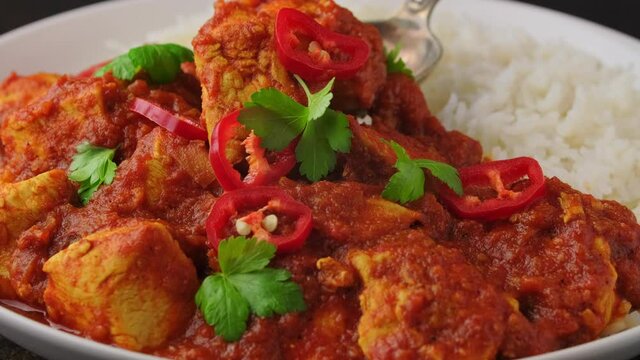 Spicy Chicken Pathia curry with basmati rice in a white plate. healthy food.