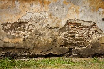 Old yellow plaster and brick wall