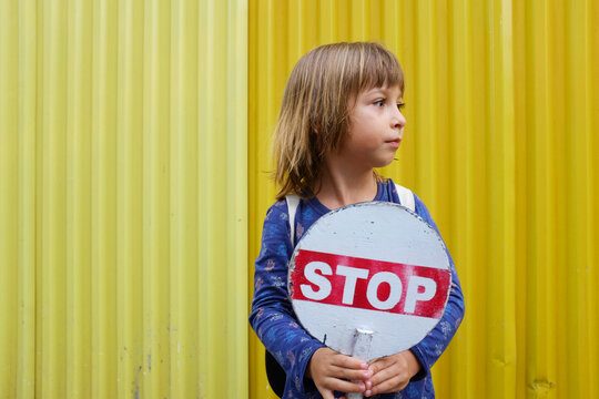 Portrait of a child boy holding a STOP sign