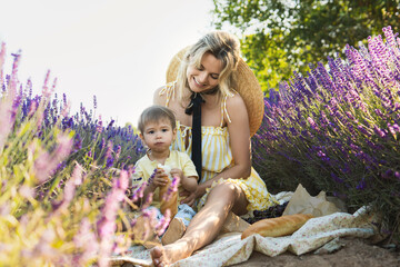 Obraz premium Beautiful woman and her cute little son in the lavender field