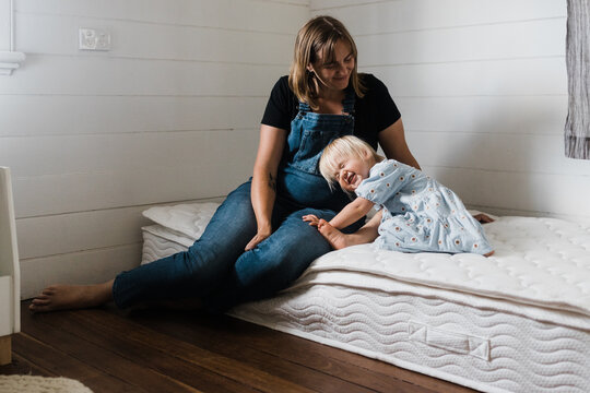 pregnant mother cuddled by toddler daughter