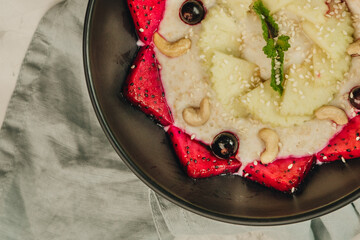 Berry smoothie with yogurt in a bowl for breakfast with blueberries, dragon fruit, cashew nuts on a white background