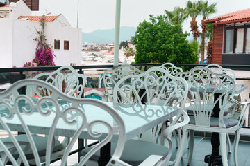 Summer open air mediterranean cafe, white and black chair on terrase or balcony, lazy afternoon