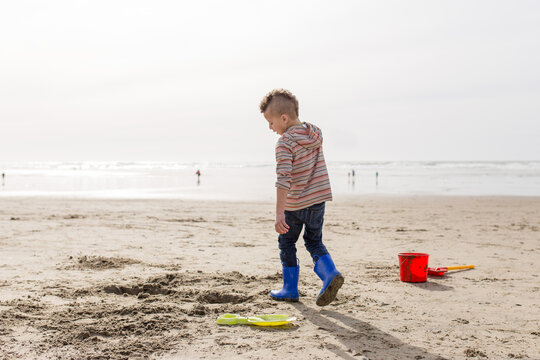 Boy digs in sand on beach