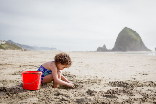 Girl digging hole in Cannon Beach