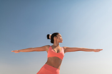 Young Asian woman practicing yoga outdoor.