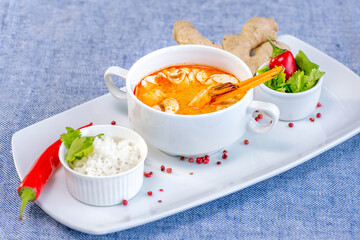 Tom yam shrimp soup beautifully served in a white bowl in the restaurant. Restaurant menu concept