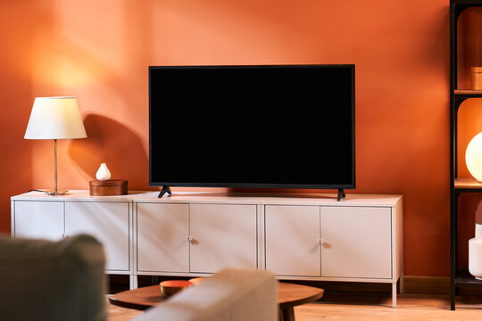 Cupboards with TV set near settee