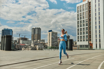 Fototapeta na wymiar Beautiful fit young woman jogger is running outdoors