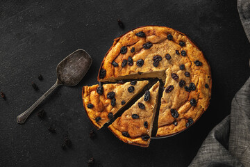fresh baked raisin pie on a black textured background, top view