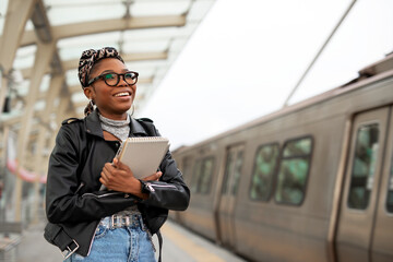 Happy young woman waiting for the train. African woman waiting for a subway train