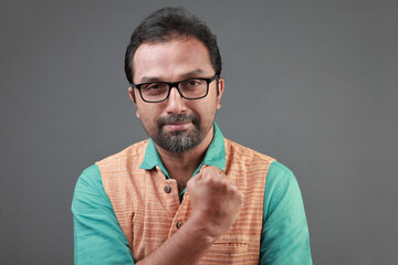 Fototapeta premium Portrait of a man of Indian ethnicity holding his fist in confidence