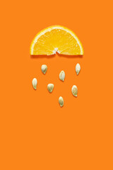 Creative food health diet concept photo of orange slice with seeds falling down like rain on orange...