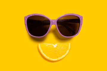 Creative food health diet concept photo of orange slice with sunglasses on orange background.