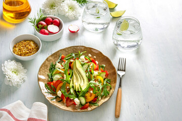 Various summer healthy vegetables salads with avocado, cucumber, radish, bell pepper and tomato.
