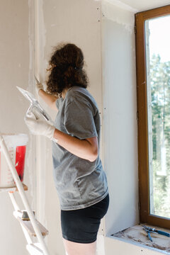 woman plastering her wall 