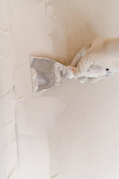 hand putting plaster on wall