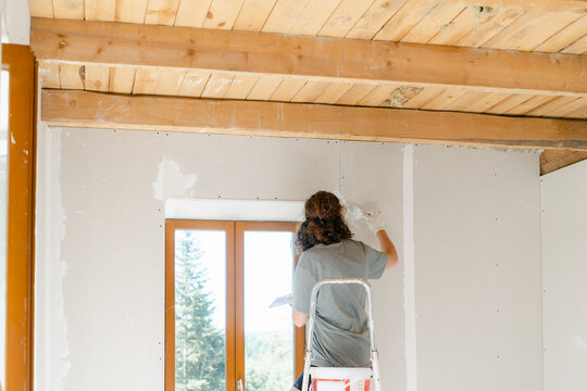 woman plastering her wall 