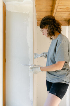 woman plastering her wall 