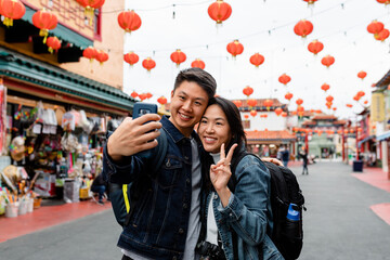 Happy Asian Couple Poses for Selfie in Front of Red Lanterns 
