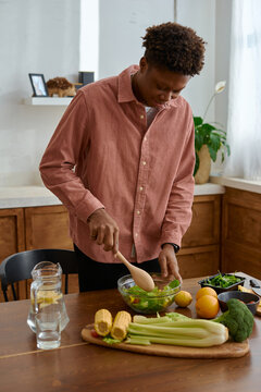 black man preparing a vegetarian meal home kitchen