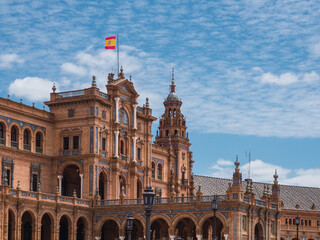 Fototapeta premium Spanish square (Plaza de Espana) in Maria Luisa park, Seville, Spain, with the Spanish flag on the facade