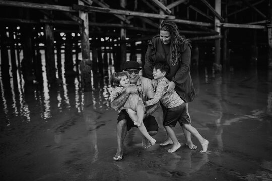 Hispanic family playing near ocean pier