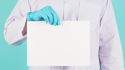 Blank board paper in doctor hand.Man wear blue latex glove and doctor on mint green or Tiffany Blue background.
