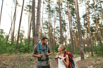 Smiling young caucasian couple walking in wood