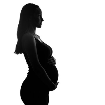 recommend clip art: silhouette portrait of pregnant woman in black dress stands sideways with hands on belly on white background, pregnancy concept
