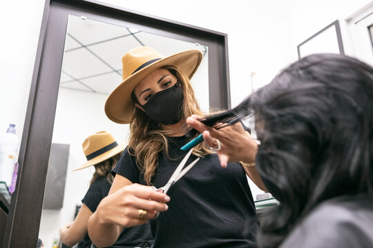 Style: Stylist Wearing Face Mask Trims Customer's Hair With Scis