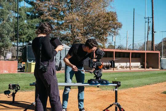 Cinematographer Filming On A Baseball Field