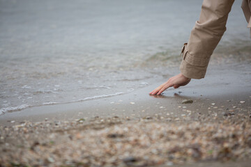 Autumn woman touching autumn sea