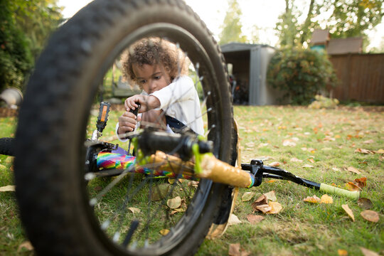 Girl with alan wrench fixes bicycle